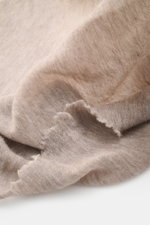 Fedeli Cashmere Tuch 'Yeti' taupe meliert in Nahaufnahme schräg fotografiert, geflammte Optik, offene Saumkanten, weiches, voluminöses Material.