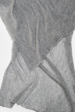 Nahaufnahme des Fedeli Cashmere Tuch 'Yeti' grau meliert, fotografiert aus schräger Draufsicht, zeigt die geflammte Optik, den voluminösen Griff und offene Saumkanten.