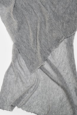 Nahaufnahme des Fedeli Cashmere Tuch 'Yeti' grau meliert, fotografiert aus schräger Draufsicht, zeigt die geflammte Optik, den voluminösen Griff und offene Saumkanten.