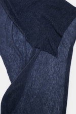 Nahaufnahme des Fedeli Cashmere Tuch 'Yeti' graublau mit geflammter Optik und offenen Saumkanten aus softem, voluminösem Griff, fotografiert von oben.
