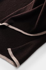 Fedeli Cashmere Schal dunkelbraun in Nahaufnahme von oben, leichter Schal mit weichem Griff, feinem Strickbild und farblich kontrastierender Kante.