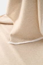 Fedeli Cashmere Schal beige in Nahaufnahme von oben, weicher Griff, feines Strickbild, kontrastierende Kante aus reinem Cashmere.