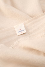Nahaufnahme aus schräger Perspektive des 19 Andrea’s 47 Cashmere Schal sand in sandfarben, reiner Cashmere, sehr weicher Griff, schmaler Fransensaum, Maße ca. 192x61 cm.