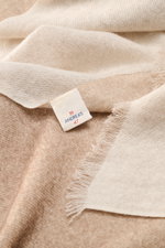 Nahaufnahme aus schräger Perspektive des andrea's 1947 Cashmere Schal beige meliert mit schmalem Fransensaum aus hauchdünnem, leichtem reinen Cashmere.