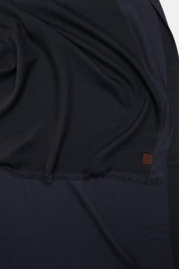 Nahaufnahme des Colombo Cashmere-Seiden-Schals dark navy von oben fotografiert, mit weich fallendem Stoff, schmalem Fransensaum und Logo-Patch.