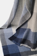 Brunello Cucinelli Scarf light grey/grey blue/navy checked shown close-up from side angle, blend of wool and cashmere, smooth touch, large checked pattern, narrow fringed hem, approx. 162 cm x 47 cm.