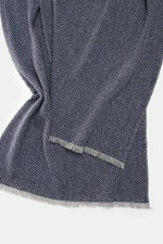 Close-up front view of the Brunello Cucinelli Cashmere scarf grey/dark blue patterned, showing its classic herringbone weave and fringed edge.

<p>Quiet-luxury label BRUNELLO CUCINELLI is known for its elegant, timeless cashmere creations – like this two-