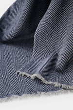 Brunello Cucinelli Cashmere scarf grey/dark blue patterned shown close-up from above, highlighting pure cashmere fabric with classic herringbone pattern and narrow fringed edge, super soft touch, dimensions approx. 165 cm x 52 cm; quiet-luxury label known