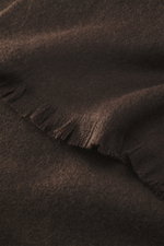 The Row Cashmere Schal 'Ingo' dunkelbraun, Detailaufnahme aus schräger Perspektive, feines, garngefärbtes Kaschmir mit weichem Griff und schmalen Fransen.