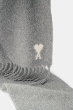 Ami Paris Schal grau meliert aus supersoftem Alpakawoll-Mix mit Fransen, Monogramm und weichem Griff, Nahaufnahme von oben.