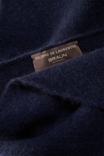 Close-up view of the Filippo de Laurentiis Bandana navy showing its soft, voluminous navy fabric and brown label with brand name.

<p>This soft bandana by FILIPPO DE LAURENTIIS is knitted from a noble material composition and is a practically lightweight 