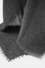 Nahaufnahme des Altea Cashmere Schals dunkelgrau meliert mit umlaufender Fransenkante, feiner, leichter Qualität, sehr weichem Griff, Strick aus reinem Cashmere, Maße ca. 180x70 cm, fotografiert aus seitlicher Perspektive.
