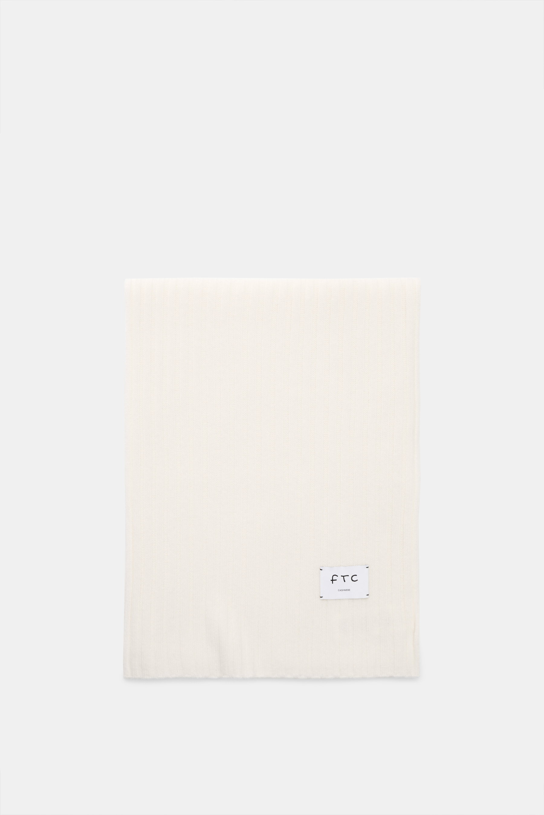 FTC Cashmere scarf off white photographed from above, showing rib knit pattern and woven logo label, pure fair trade cashmere.

Description: 
<p>An elegant, sustainably produced accessory for cold days: This scarf with rib knit pattern by FTC is made of l
