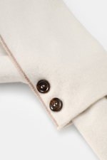 Close-up top-down view of the Moorer Cashmere scarf cream/taupe showing its fine knit pattern, two horn buttons, and soft double-layered cashmere fabric. This narrow, warming scarf in luxurious, double-layered cashmere quality by MOORER is an indispensabl