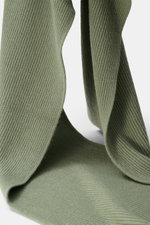 Nahaufnahme des 04651/ A trip in a bag Cashmere Schal salbei aus reinem Cashmere-Rippstrick mit klassischem Patentmuster, fotografiert von schräger Perspektive.