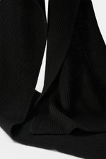 Nahaufnahme des 04651/ A trip in a bag Cashmere Schal schwarz in klassischem Patentstrickmuster aus reinem Cashmere, seitlich liegend fotografiert.