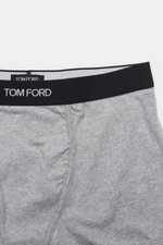 Tom Ford Boxershorts grau aus elastischer Baumwolle, Slim Fit, mit seitlichem Eingriff und schwarzem Bund mit TOM FORD-Stitching, Draufsicht.