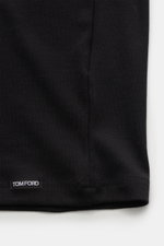 Close-up of the bottom hem of the Tom Ford Rundhals-Unterhemd schwarz, showing the small TOM FORD web label on elastic, soft, black cotton fabric in slim fit with a round neckline, photographed from a flat lay perspective.

Description: <p>Cleanes Basic m