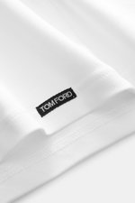 Close-up view of the hem of the Tom Ford V-Neck Unterhemd schwarz showcasing the small black woven label, made of cotton jersey with comfortable stretch, very soft touch, extra slim fit, and V-neck design.