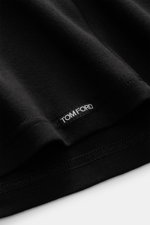 Close-up image of the hem of the Tom Ford V-Neck Unterhemd navy, photographed from a side angle, showing the small woven Tom Ford label on the very soft, extra slim fit cotton jersey fabric with comfortable stretch. Features include: Jersey aus Baumwolle,