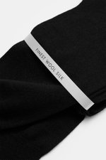 Close-up angled view of folded black Falke Strumpf 'No. 7' schwarz socks with a "Finest Wool Silk" label, showing fine texture.

<p>Optimale Passform, luxuriöse Materialqualität, FALKE: Der Strumpf 'No. 7' des Traditionslabels garantiert durch feinste two