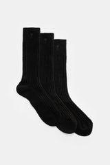 A front perspective view of Ami Paris Strümpfe 3er-Set schwarz, three black ribbed socks with reinforced zones, wide cuffs, and heart stitching. Vom Basic zum Statement mit Herzensangelegenheit schaffen es die Strümpfe im 3er-Set von AMI PARIS, die das fr