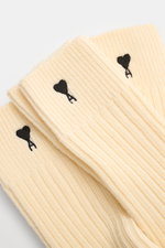 Ami Paris Strümpfe 3er-Set creme shown from a close-up top-down perspective, featuring ribbed texture, wide cuffs, reinforced zones, and black heart stitching with an "A". <p>Vom Basic zum Statement mit Herzensangelegenheit schaffen es die Strümpfe im 3er
