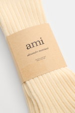 Close-up front view of Ami Paris Strümpfe 3er-Set creme ribbed socks with kraft paper label showing brand and origin.

<p>Vom Basic zum Statement mit Herzensangelegenheit schaffen es die Strümpfe im 3er-Set von AMI PARIS, die das französische Label mit se