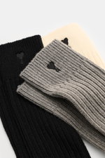 Ami Paris Strümpfe 3er-Set creme/grau/schwarz displayed from a top-angle view, showing ribbed texture, wide cuffs, heart stitching, and reinforced zones. <p>Vom Basic zum Statement mit Herzensangelegenheit schaffen es die Strümpfe im 3er-Set von AMI PARIS