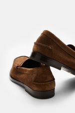 Church's Penny Loafer 'Rowley' braun aus geschmeidigem Veloursleder mit Ziernähten, Penny-Strap, ledernem Innenfutter, Goodyear-welted, von hinten schräg fotografiert.