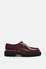 Side view of Collegium Derby 'Pillar Moc-Toe' bordeaux in polished smooth leather with narrow silhouette, two-hole lace, decorative toe stitch, leather lining, and black rubber lug sole, eyecatcher for transitional seasons.