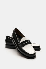 G.H.Bass Penny Loafer 'Weejuns Larson' schwarz/weiß shown from front side angle, black and white leather with penny strap, stitched edges, leather lining, cushioned footbed, leather sole, rubber reinforced heel; Schuhe, die Geschichte schrieben: Der Penny
