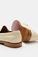 G.H.Bass Penny Loafer 'Weejuns Larson' creme shown from rear and sole perspective, featuring smooth leather, stitched construction, narrow silhouette, penny strap, decorative lacing, leather lining, comfortable footbed, leather sole, rubber-reinforced hee