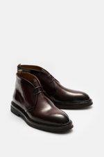 Officine Creative Chelsea Boot 'Dude Flexi' black shown from a front-side angle, polished smooth leather, Goodyear welted, slightly tapered silhouette, side elastic inserts, practical pull tab, leather lining, natural rubber outsole. Move versatilely thro