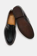 Officine Creative Penny Loafer 'Opera Flexi' black shown from top and sole views, featuring noble smooth leather, narrow tapered silhouette, Goodyear-welted construction, typical penny strap, toe cap with decorative seam, leather lining, and rubber outsol