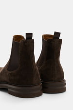 Rear close-up of Officine Creative Chelsea Boot 'Dude Flexi' braun in polished leather with elastic sides and pull tabs, showcasing fine stitching and sole details.
