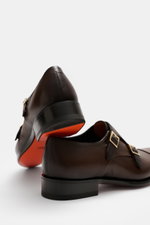 Rear and side view of Santoni Double Monk 'Carter' Dark Brown in grained leather with gold-colored pin buckles and red sole.

<p>Exquisite craftsmanship turns this elegant double monk by SANTONI into a shoe of flawless Italian chic, perfectly complementin