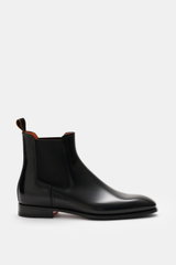 Santoni Chelsea Boot 'Adrian' black shown from side view, polished smooth leather, narrow tapered silhouette, side elastic inserts, pull tab, leather lining, leather sole with rubber insert, classic Italian style for suit or casual office look.