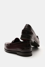 Santoni Penny Loafer 'Quentin' bordeaux, Foto von schräg hinten, softes Veloursleder, schmale Silhouette, Ziernaht, Penny-Strap, ledernes Innenfutter, flexible Kautschuksohle, Kautschukverstärkung am Absatz.
