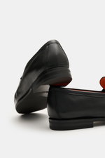 Santoni Loafer 'Carter' schwarz aus feinem Glattleder, handgefärbt, mit orangener Sohle, Penny-Strap, Steppnaht, Lederfutter, Ansicht von hinten schräg.