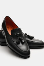 Santoni Tassel-Loafer 'Carter' schwarz, frontal von oben fotografiert, mit geschmeidigem Leder, schmal zulaufender Silhouette, Ziernaht, typischer Tassel, ledernem Innenfutter, flexibler Kautschuksohle und Kautschukverstärkung am Absatz.