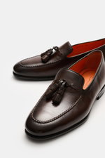 Santoni Tassel loafer 'Carter' brown shown from a close-up angled top-front view, featuring supple leather, narrow tapered silhouette, front cap with decorative seam, typical tassel, leather lining, flexible rubber sole, and rubber reinforcement on the he