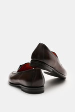 Santoni Tassel loafer 'Carter' brown shown from rear-side angle, featuring supple leather, narrow tapered silhouette, front cap with decorative seam, typical tassel, leather lining, flexible rubber sole, and rubber reinforcement on the heel.