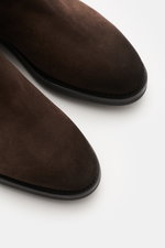 Nahaufnahme des braunen Santoni Chelsea Boot 'Colin' aus geschmeidigem Veloursleder, schmal zulaufend, rahmengenäht, seitliche Elastikeinsätze sichtbar.