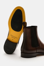 Doucal's Chelsea boot 'Orvieto Flex' brown shown from side and sole view, featuring noble smooth leather, narrow tapered silhouette, elastic inserts, leather lining, and leather sole with rubber parts.