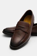 Doucal's Penny Loafer 'Nottingham' dunkelbraun aus fein genarbtem Leder mit Farbverlauf, schmal zulaufend, Steppnaht, Pennystrap, Gummisohle, von schräg oben fotografiert.