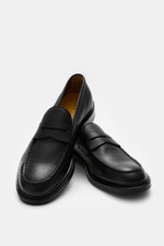 Doucal's Penny Loafer 'Siena Flex' schwarz aus fein genarbtem Leder mit Steppnaht, Pennystrap, Lederfutter, durchgenähter Sohle, seitliche Ansicht.