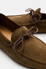 Close-up front-side view of Tom Ford Loafer braun in soft brown velour leather with leather bow, decorative stitching, and leather interior.

Description: <p>Mit diesem modernen Loafer im Mokassin-Stil aus feinstem Veloursleder mit Schleife und praktische