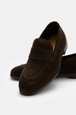 Henderson Penny Loafer 'Moro' dark brown shown from a close-up front-side perspective, made of supple suede leather with a narrow tapered silhouette, typical penny strap, decorative seam on the front cap, Goodyear-welted construction, leather lining, rubb