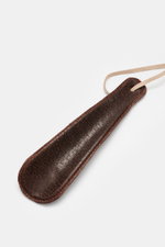 Close-up top view of brown leather shoehorn with orange stitching for the Henderson Penny Loafer 'Cervo' dark brown. 

Description: Stylish classic: The 'Cervo' loafer from HENDERSON made of supple leather impresses with its typical penny-strap design and
